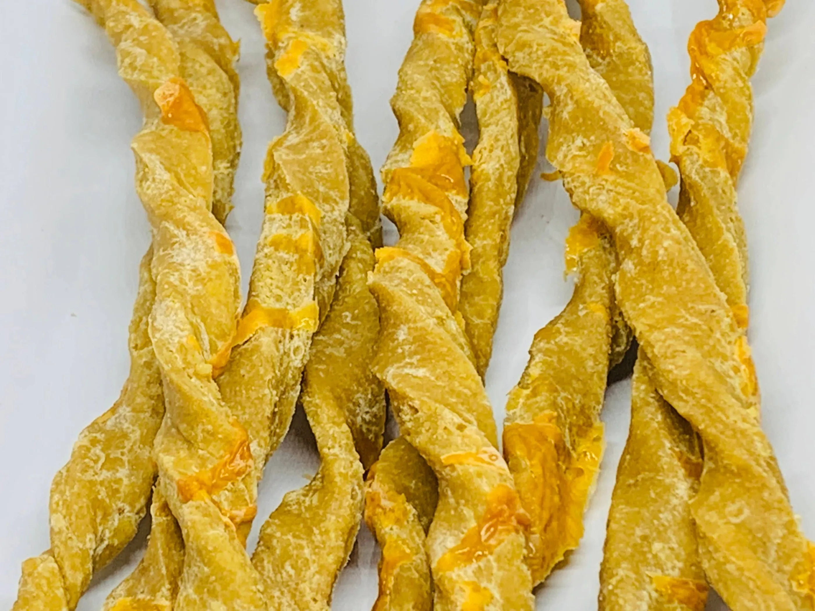 Dog treats featuring Parmesan and Cheddar cheese from The Blue Cerebus Dog Bakery, shown as a tasty cheese stick for dogs.