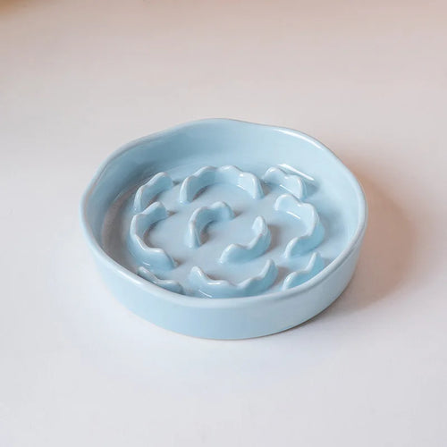 White ceramic slow food cat bowl with high footed design and neck protection features for comfortable feeding.